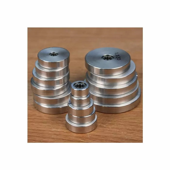 Stacked metal router bearings for woodworking on a wooden surface