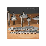 Assorted woodworking router bits and roundover bearing guides on a wooden workbench