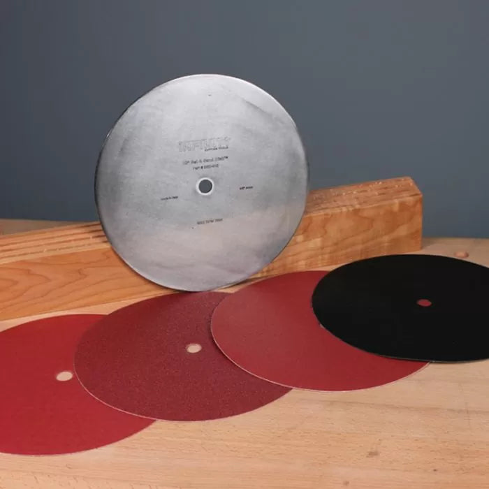 Woodworking sanding discs and metal disc sander plate on workbench with wood block