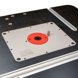 Close-up of woodworking router table insert plate with red ring and miter track