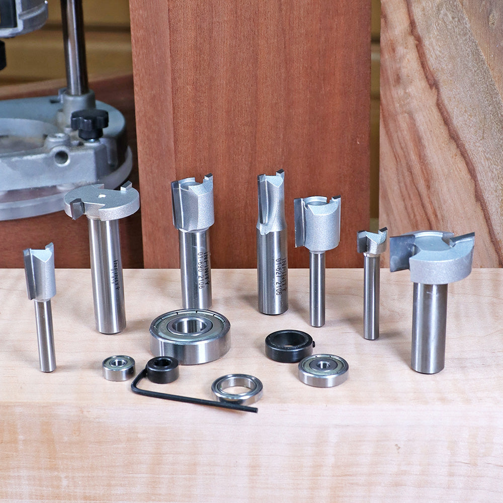 Assorted woodworking router bits and bearings displayed on a wooden workbench