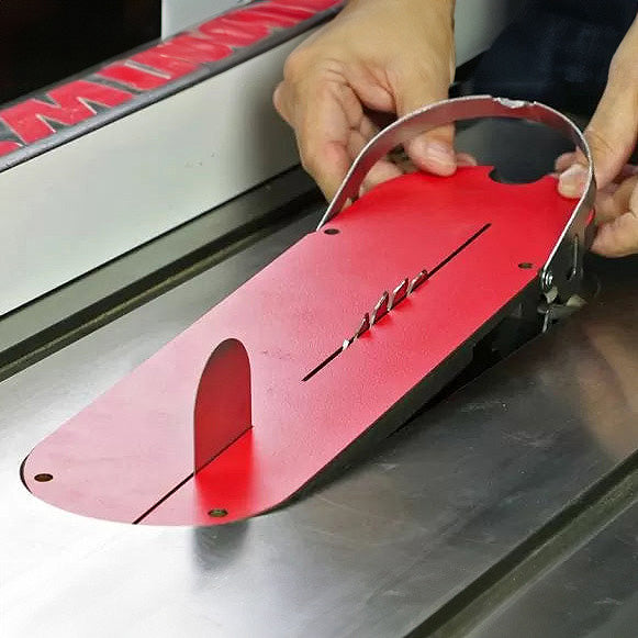 Person installing red zero clearance table saw insert with riving knife for woodworking.