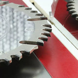 Close-up of a carbide-tipped table saw blade with sharp teeth on a red saw insert, woodworking tool.