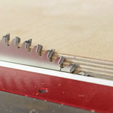 Close-up of a circular saw blade cutting plywood on a table saw for woodworking