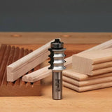 Router bit for woodworking with sample profiled wooden trim pieces on a workbench