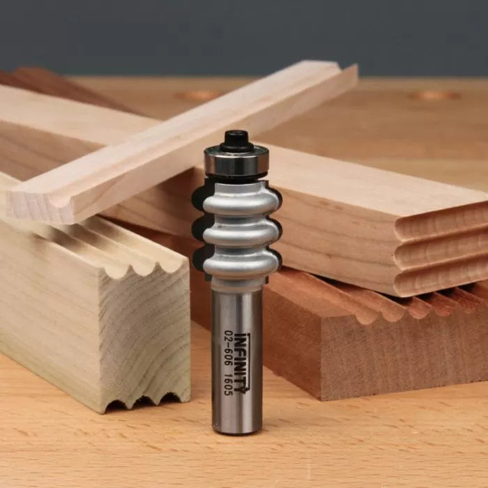 Roundover edge router bit with sample molded wood pieces on a workbench, woodworking tool