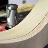 Carbide spiral router bit shaping smooth curved wood edge on a router table