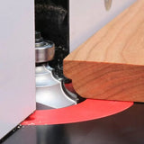 Wooden board on router table with roundover router bit shaping the edge