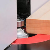 Router bit cutting profile edge on wooden board with router table for woodworking