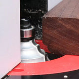 Close-up of a router bit shaping the edge of a wooden board on a router table
