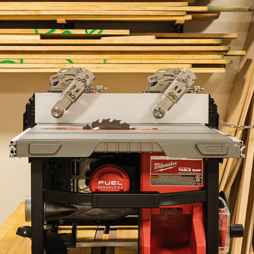 Portable table saw with precision fence and featherboard accessories in woodworking shop