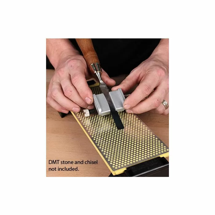 Hands using a honing guide to sharpen a chisel on a diamond sharpening stone