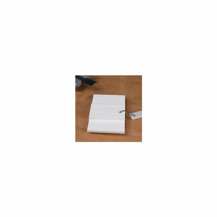 White plastic crown molding gauge on wooden workbench for woodworking projects