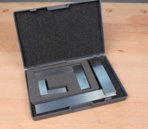 Set of steel woodworking squares and rule in foam-lined case on workbench