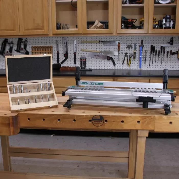 Dovetail jig and router bit set on woodworking bench in workshop