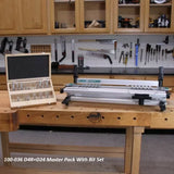 Dovetail jig and router bit set on workbench in woodworking shop with tools in background.