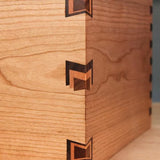Close-up of wooden box corner with decorative butterfly joints and precision dovetail joinery