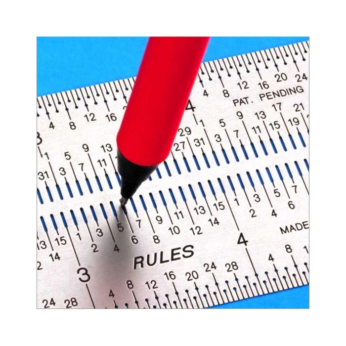 Red pen marking precise measurement on metal woodworking ruler with clear scale markings