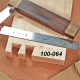 Woodworking dovetail joint sample with steel ruler and marking gauge on wooden surface