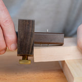 Ebony marking gauge tool used on wood for precise woodworking measurements