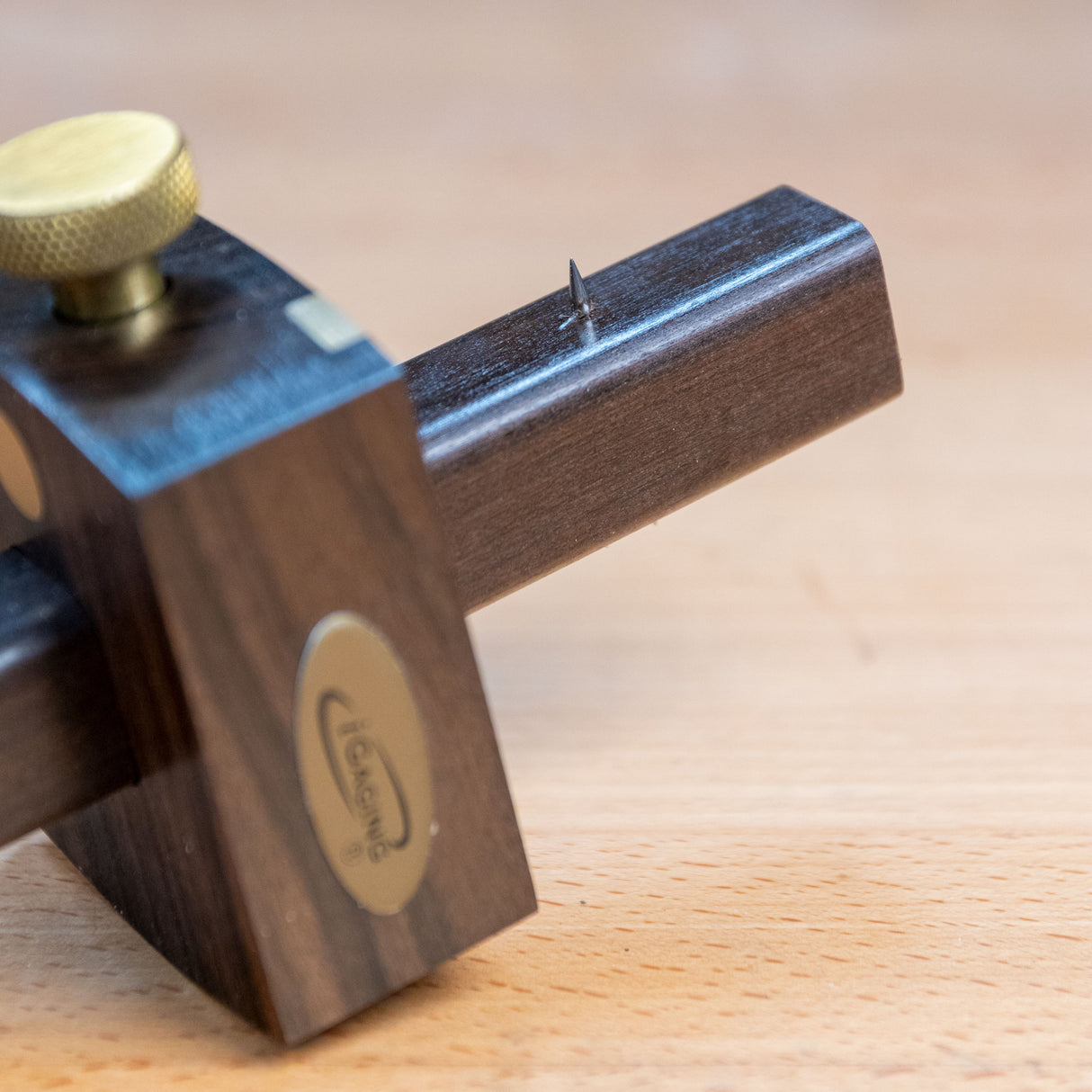 Ebony marking gauge with brass knob on wooden surface for precise woodworking layout