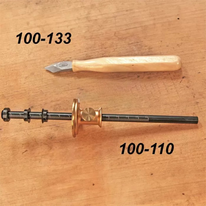 Woodworking marking knife and adjustable marking gauge on wooden surface