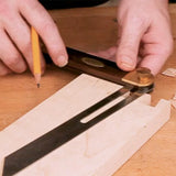Woodworker using bevel gauge and pencil to mark angle on wooden board