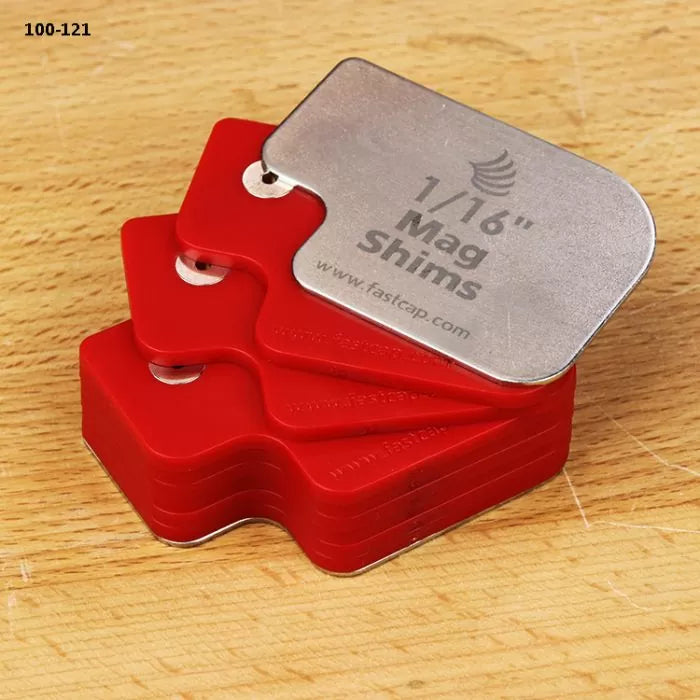 Red and silver 1/16 inch magnetic shims for woodworking on a wood surface