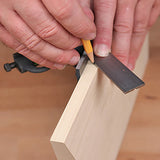 Woodworker marking a precise line on a board using a combination square and pencil