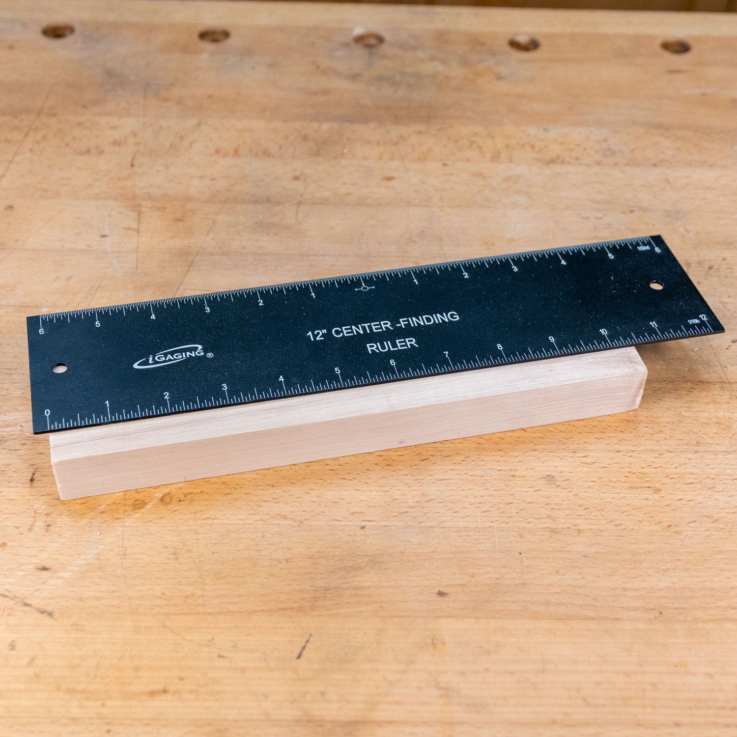 12-inch center-finding ruler measuring a wooden block on a workbench