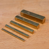 Brass setup bars set for woodworking, arranged on a wooden surface