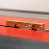 Brass setup bar measuring blade height on tablesaw for precise woodworking cuts.