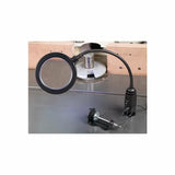 LED magnifying lamp with flexible arm and clamp set on a woodworking table