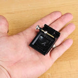 Small woodworking blade sharpening jig with metal screw held in hand on wood surface