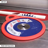 Blue and red saw blade storage disc for woodworking, lying on a table saw surface.