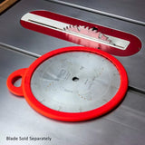 Table saw blade with red protective cover lying on metal saw table, woodworking tool