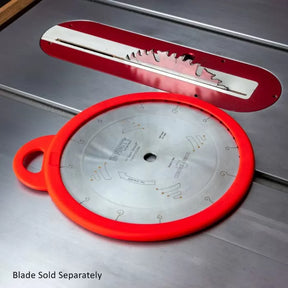 Table saw blade with red protective cover lying on metal saw table, woodworking tool