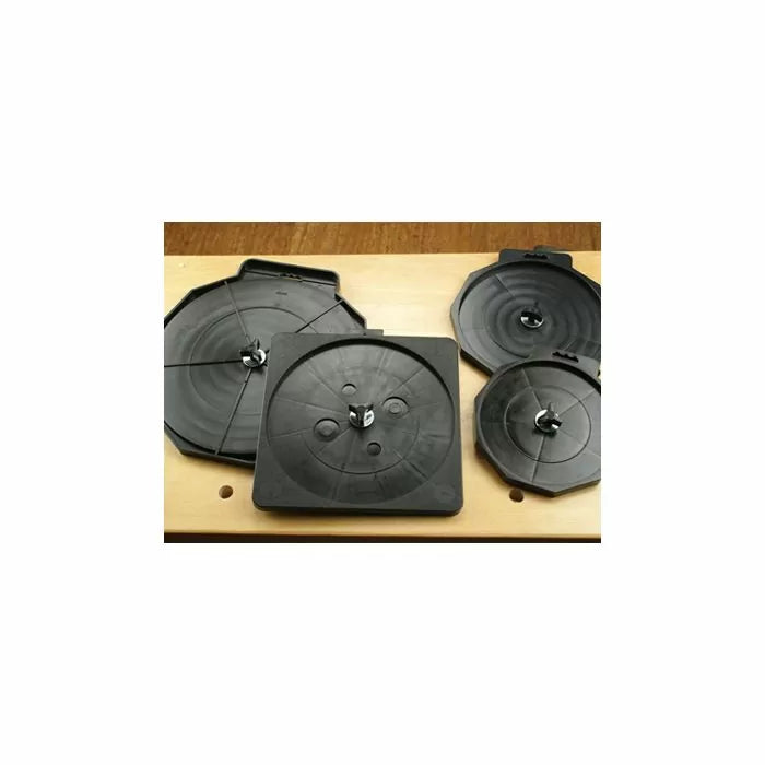 Set of four black router bit storage trays on a wooden workbench for woodworking tools