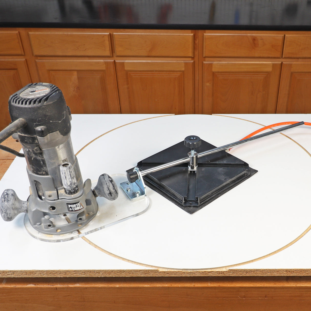 Wood router and circle cutting jig on workbench for precise woodworking cuts