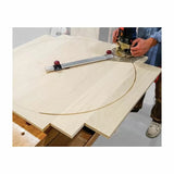 Woodworker using a router circle jig to cut a large arc in a plywood panel on a bench