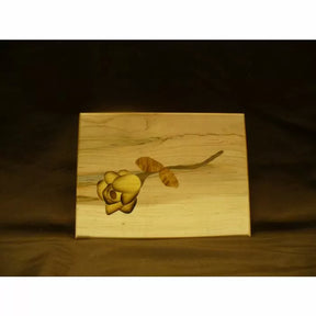 Wooden keepsake box with yellow flower inlay, woodworking project on light wood background