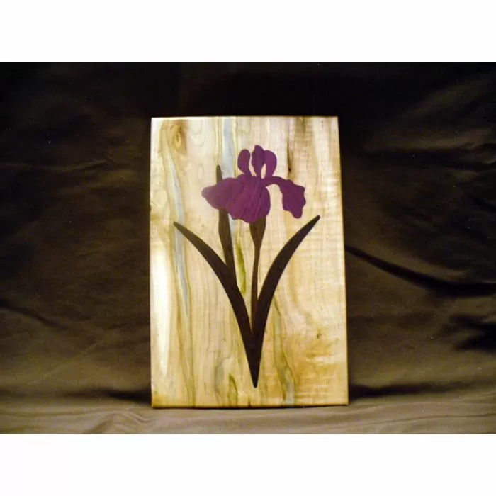Wood inlay panel with purple iris flower design, woodworking project on natural wood background