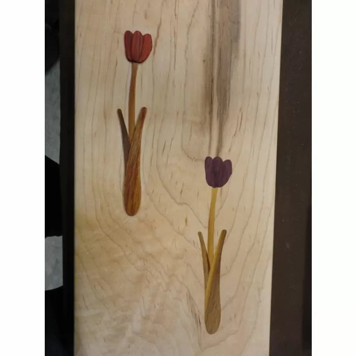 Wood inlay panel with two floral tulip designs on a light wood background