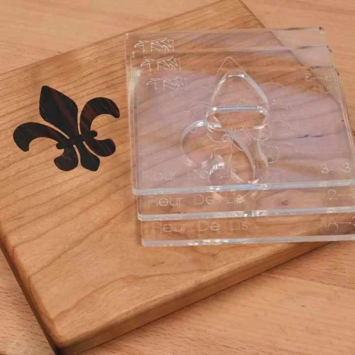 Fleur de lis woodworking inlay templates on wood with inlay accent, woodworking tools