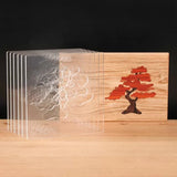 Acrylic bonsai tree woodworking templates set beside a finished wooden inlay panel
