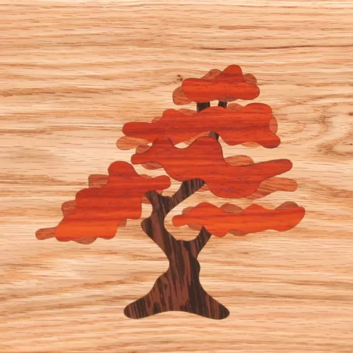 Wood inlay of a tree with reddish leaves on a light wood background, woodworking detail