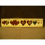 Woodworking inlay project with multiple heart-shaped patterns on a rectangular wood board
