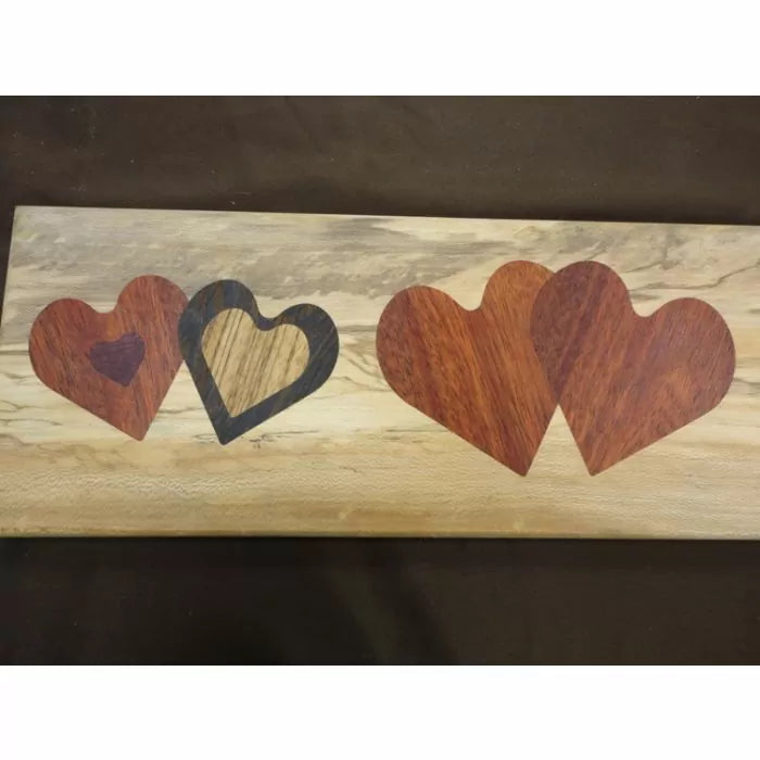 Wood inlay panel with multiple heart shapes in different wood tones, woodworking project