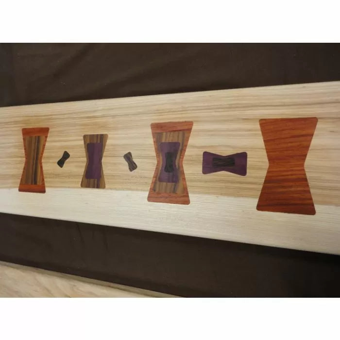 Wood board with inlaid butterfly key joints in various shapes and exotic wood colors, woodworking detail