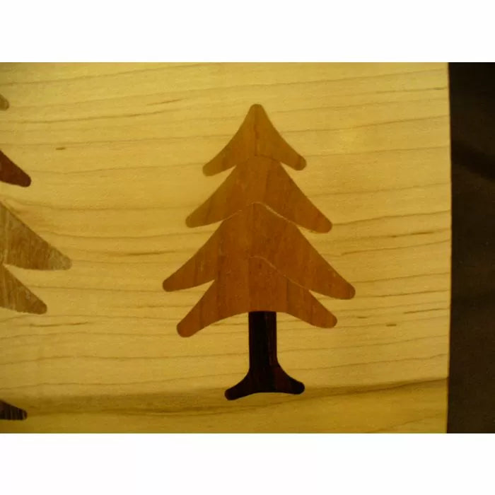 Inlaid wood pine tree pattern on light wood surface, showcasing precision woodworking